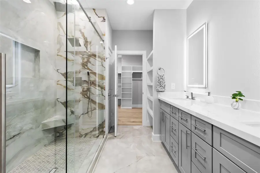 The walk-in shower, framed in glass and marble-style tile, gives you a daily dose of luxury while leading straight into your roomy closet. The walk-in shower, framed in glass and marble-style tile, gives you a daily dose of luxury while leading straight into your roomy closet.