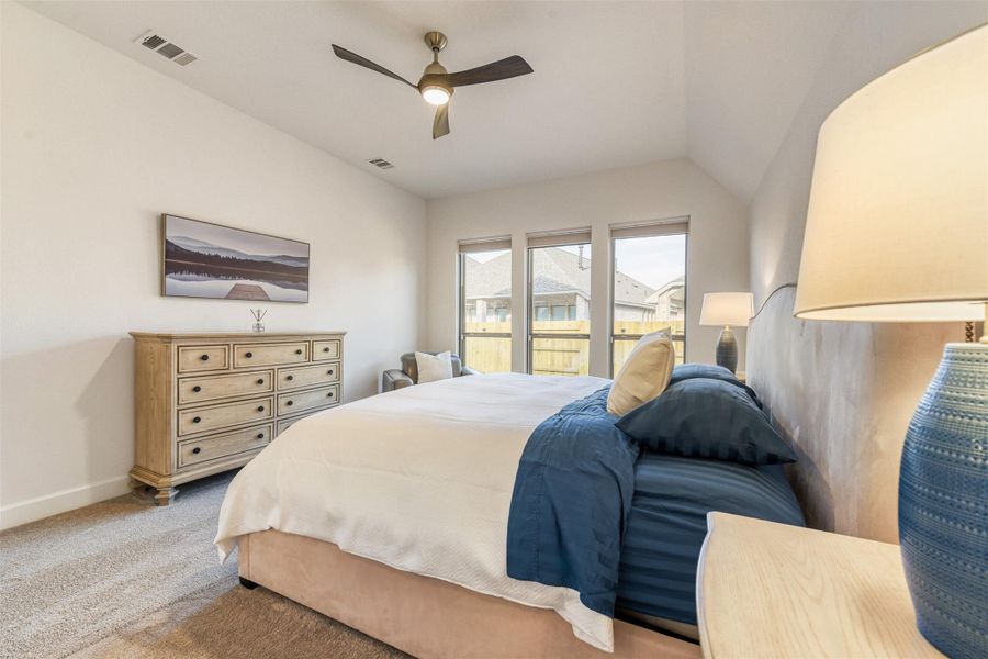 Bedroom featuring a ceiling fan, carpet, and vaulted ceiling