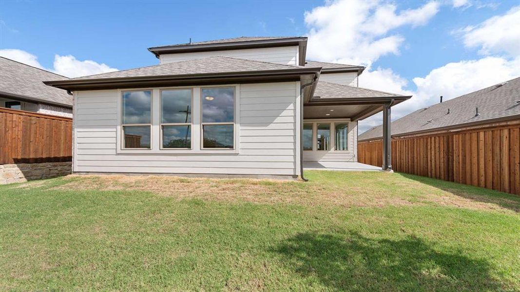 Back of house with a lawn and a patio area