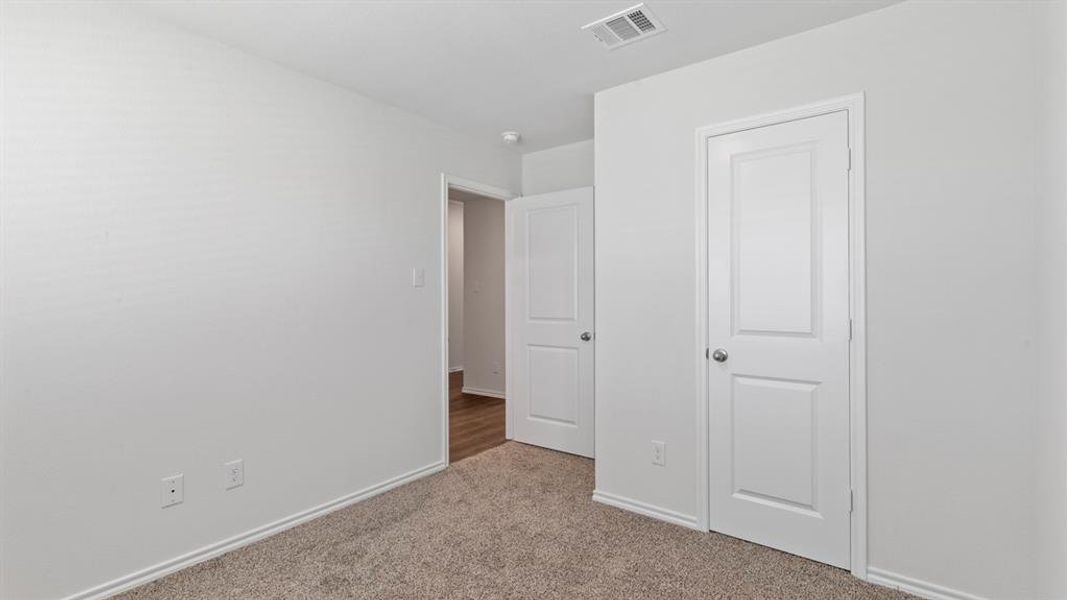 Interior room featuring neutral wall paint, white trim, and plush carpet flooring