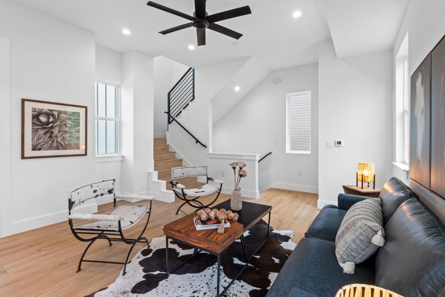 Natural light floods this inviting living space showcasing clean architectural lines and warm wood floors.