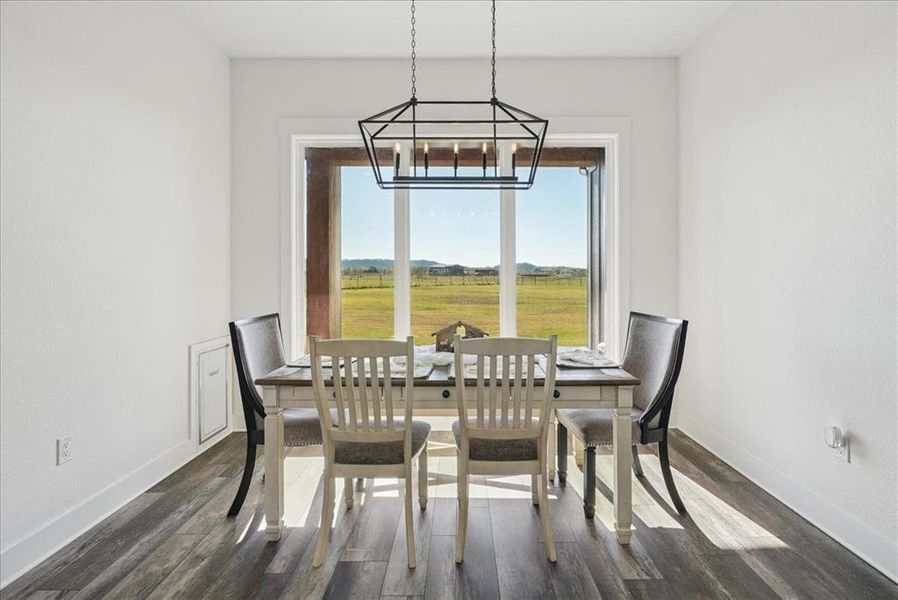 Dining area featuring dark wood-type flooring and baseboards