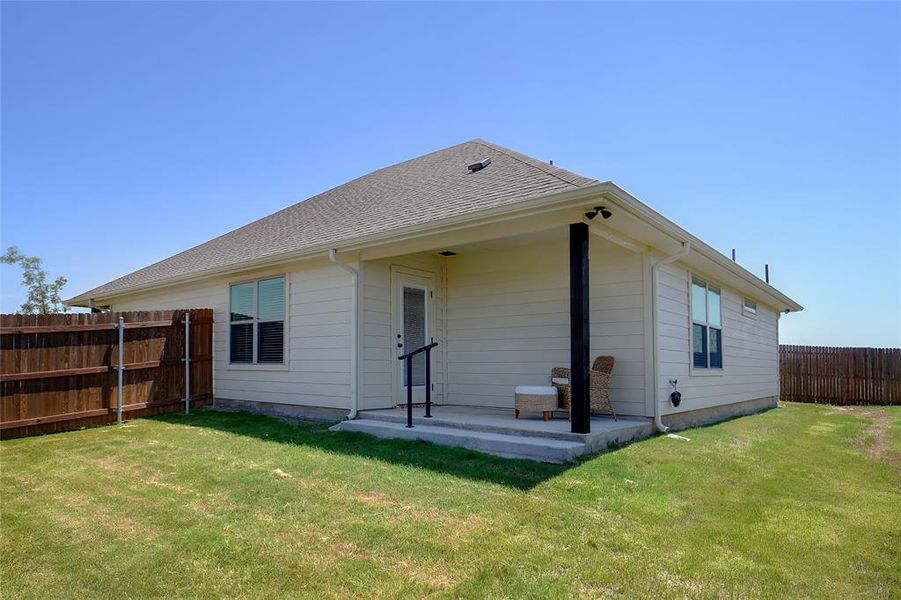 Rear view of house featuring a patio and a yard