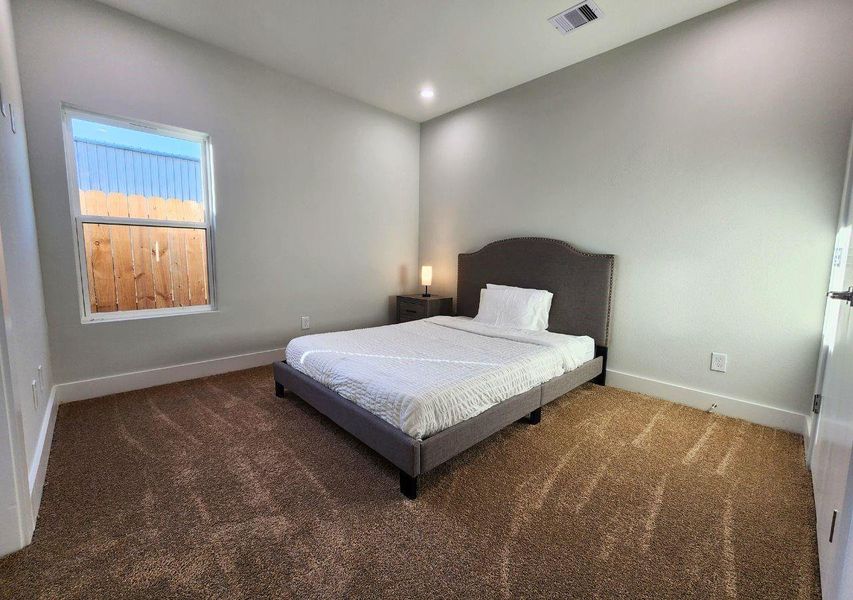 This bedroom features a minimalist design with neutral walls, cozy carpet, and a window allowing natural light. It includes a simple bed and nightstand, ideal for a relaxing retreat. This bedroom features a minimalist design with neutral walls, cozy carpet, and a window allowing natural light. It includes a simple bed and nightstand, ideal for a relaxing retreat.