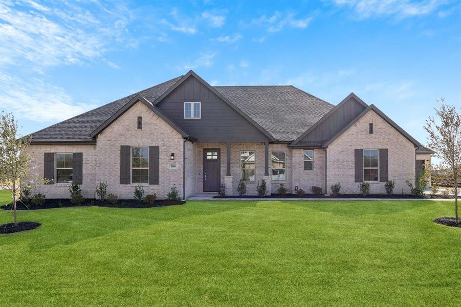 View of front of property featuring a front yard, brick siding, a shingled roof, and board and batten siding View of front of property featuring a front yard, brick siding, a shingled roof, and board and batten siding