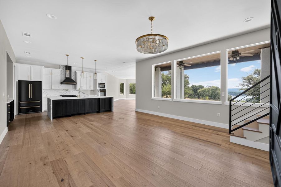 Rich wood floors sweep through this airy, open-concept living area and adjacent designer kitchen.