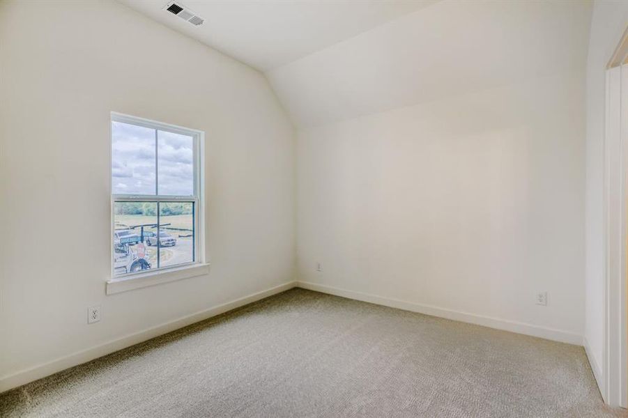 Additional living space with lofted ceiling and light carpet