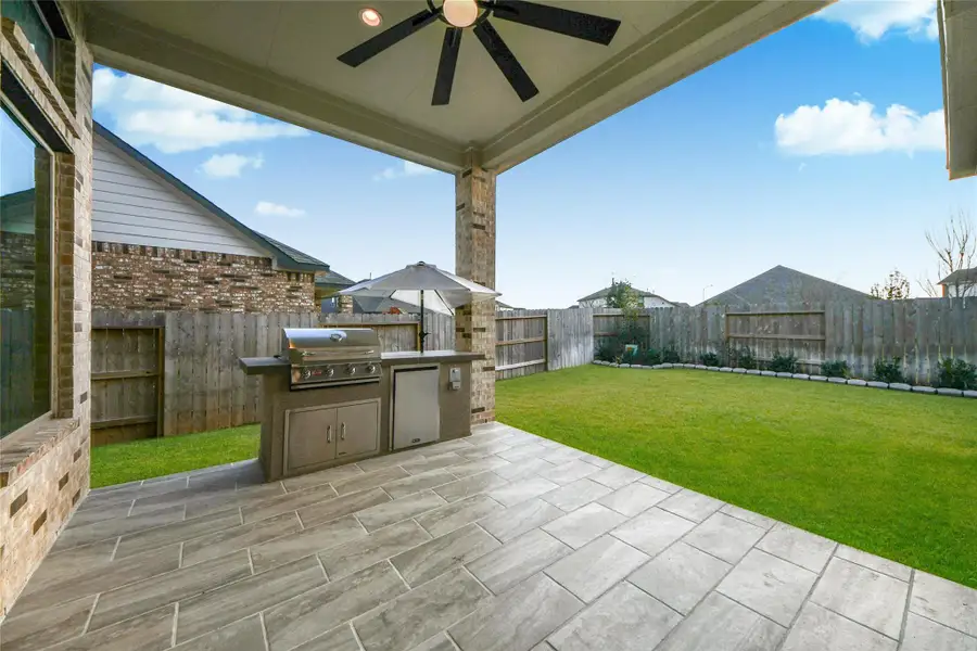 Covered back patio with seller-upgraded ceramic tile flooring, creating an ideal outdoor space for relaxing or entertaining, plus backyard irrigation for added convenience.