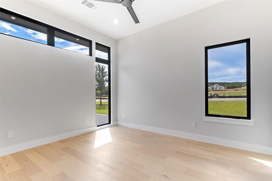 Empty room featuring ceiling fan, light wood-style floors, and baseboards Empty room featuring ceiling fan, light wood-style floors, and baseboards