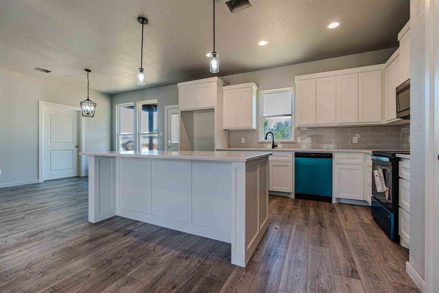 Kitchen with black / electric stove, white cabinetry, tasteful backsplash, dishwashing machine, and recessed lighting Kitchen with black / electric stove, white cabinetry, tasteful backsplash, dishwashing machine, and recessed lighting