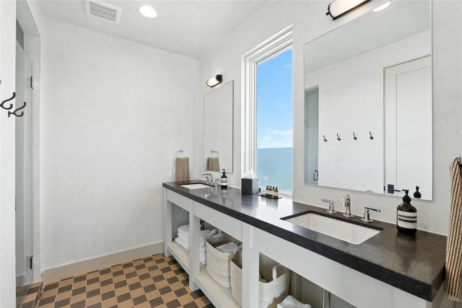 Bathroom with dark flooring and double vanity