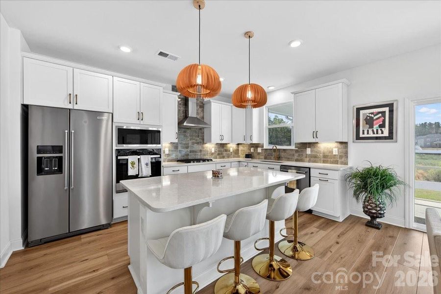 Chef's kitchen with gas cooktop, SS appliances, SS exhaust hood, and more.