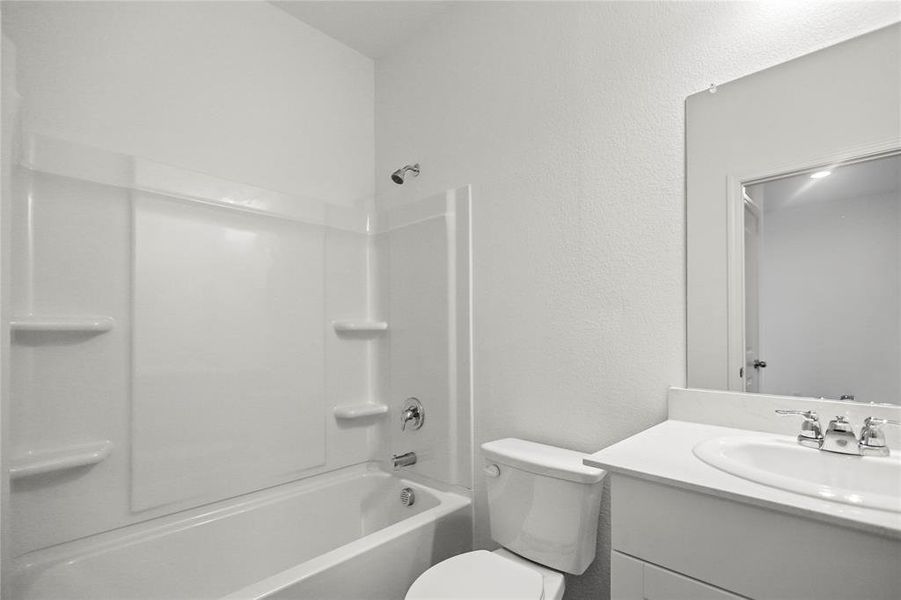 Full bathroom with combined tub/shower and single-sink vanity under bright lighting.