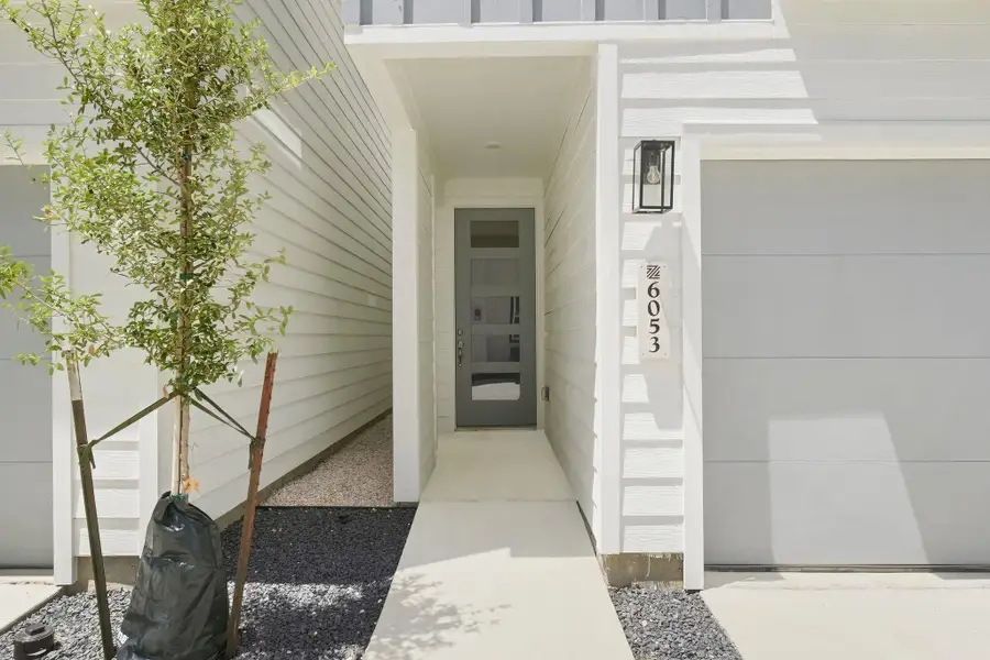 Modern front entry featuring a contemporary door with glass panels that allows natural light into the home. Modern front entry featuring a contemporary door with glass panels that allows natural light into the home.
