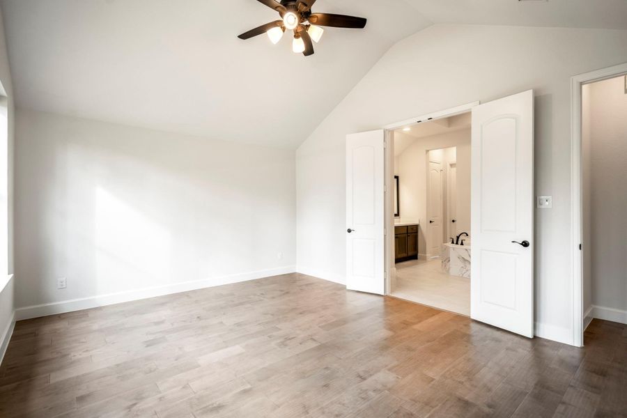 The primary bedroom features double doors leading to an en-suite bathroom.