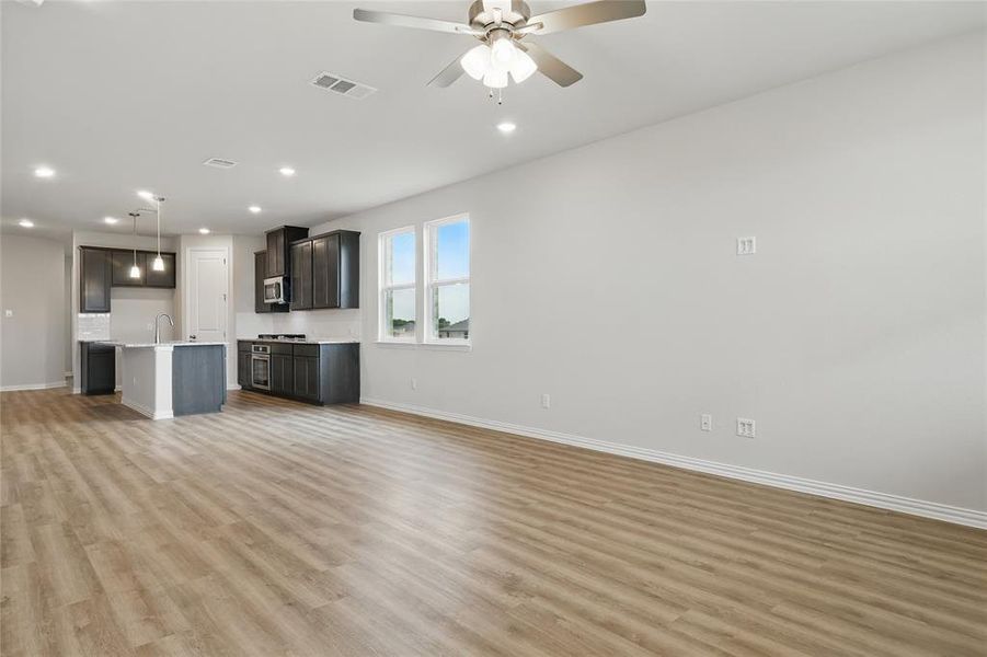 Unfurnished living room with light wood-style floors, recessed lighting, and ceiling fan Unfurnished living room with light wood-style floors, recessed lighting, and ceiling fan