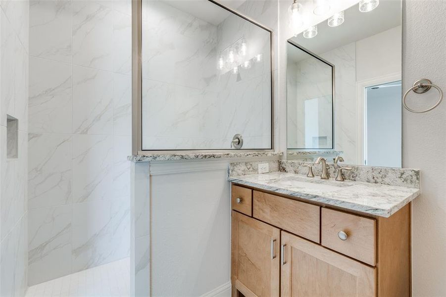 Bathroom with vanity and a marble finish shower Bathroom with vanity and a marble finish shower