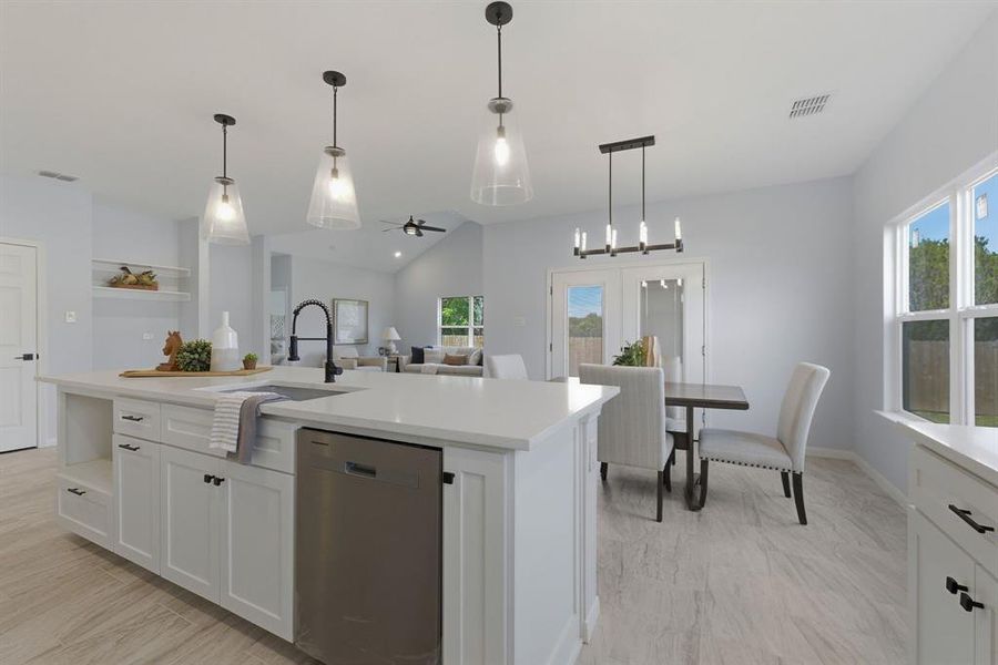 Kitchen featuring stainless steel dishwasher, vaulted ceiling, white cabinetry, a center island with sink, and ceiling fan Kitchen featuring stainless steel dishwasher, vaulted ceiling, white cabinetry, a center island with sink, and ceiling fan