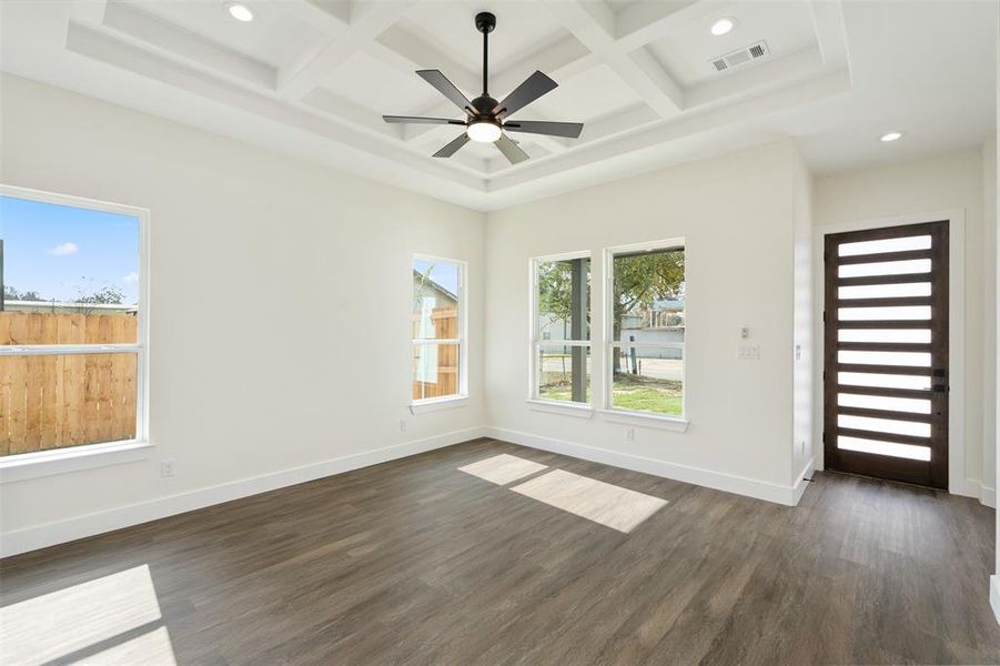 Empty room featuring recessed lighting, dark wood finished floors, a ceiling fan, beamed ceiling, and coffered ceiling Empty room featuring recessed lighting, dark wood finished floors, a ceiling fan, beamed ceiling, and coffered ceiling