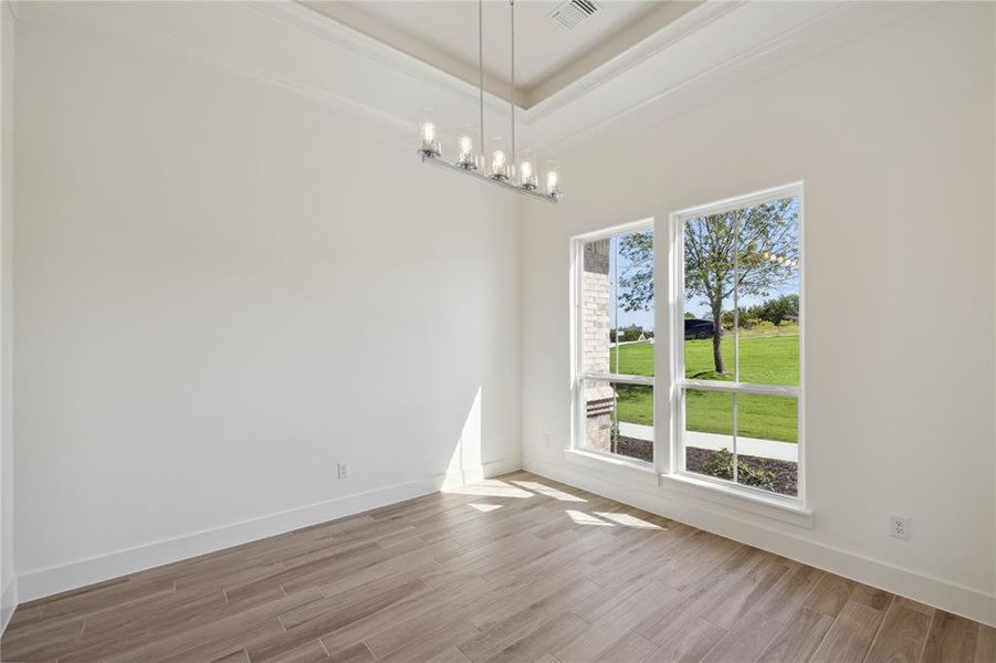 Unfurnished room with light hardwood / wood-style flooring, a chandelier, and crown molding