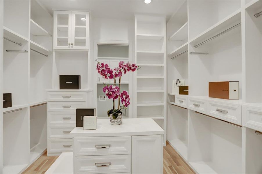 PRIMARY WARDROBE: Pocket entry door with triple mirrors on both sides, packing island, 13 built-in drawers with nickel cup pulls, triple layer storage with polished rods along with shoe shelves plus entry directly into the downstairs utility room.