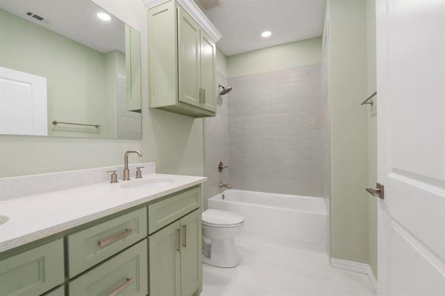 Full bathroom featuring tile patterned floors, vanity, tiled shower / bath, and toilet