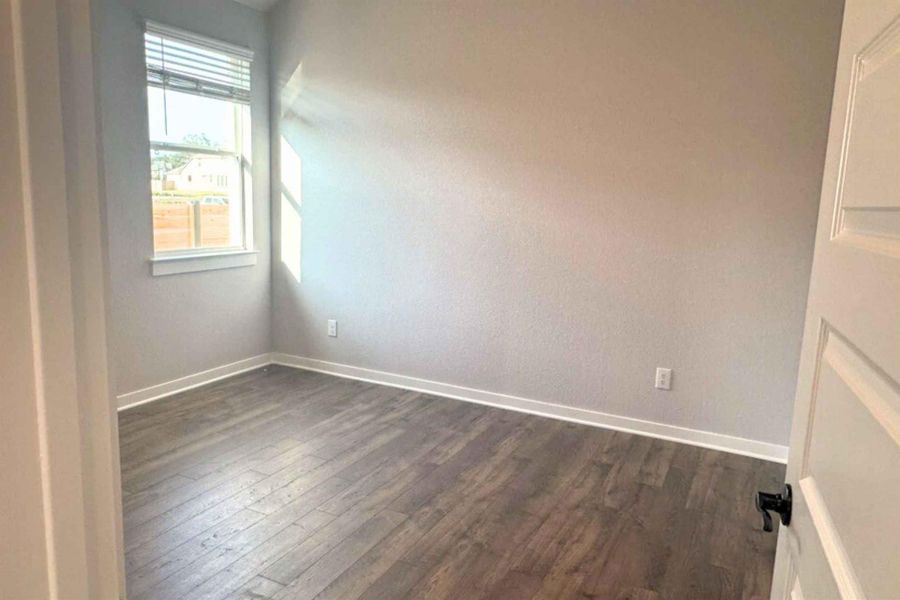 Empty room with dark wood-style floors and baseboards Empty room with dark wood-style floors and baseboards