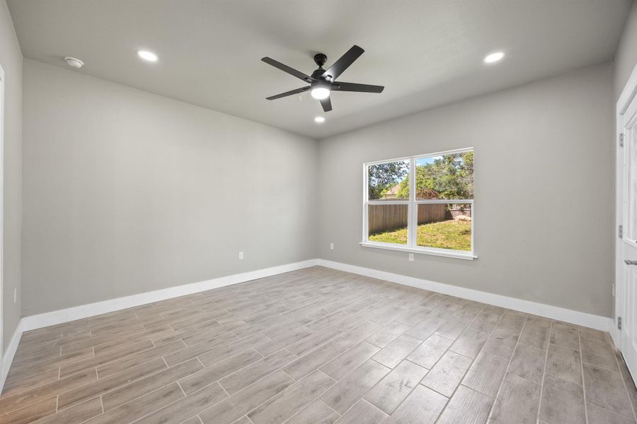 Empty room with recessed lighting, baseboards, a ceiling fan, and wood finished floors Empty room with recessed lighting, baseboards, a ceiling fan, and wood finished floors
