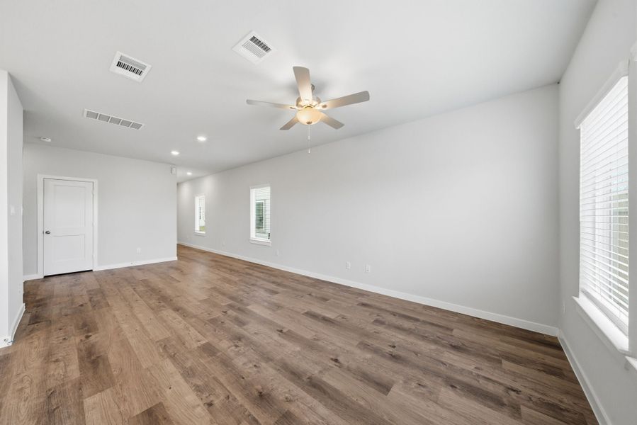 A room with a ceiling fan and wood floor. A room with a ceiling fan and wood floor.