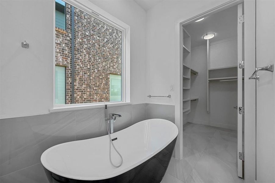 Bathroom with a washtub and tile walls