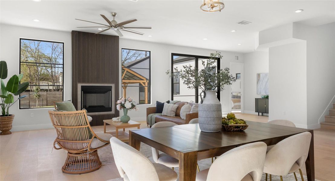 Dining area with a large fireplace, ceiling fan, healthy amount of natural light, recessed lighting, and light wood-style floors