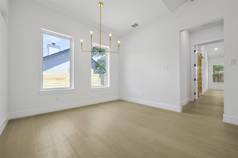 Unfurnished dining area featuring light wood-style flooring and a chandelier
