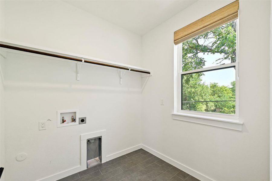 Second-floor laundry room located off the primary suite, with built-in shelving and natural light. Second-floor laundry room located off the primary suite, with built-in shelving and natural light.
