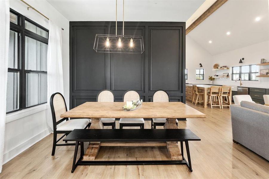 Dining space featuring beamed ceiling, light wood-style floors, recessed lighting, and high vaulted ceiling