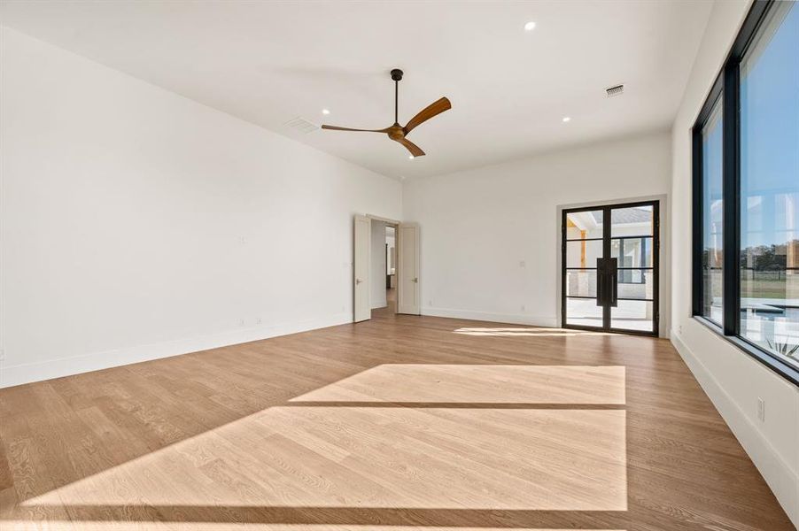 Spare room featuring light wood-type flooring, a ceiling fan, and recessed lighting