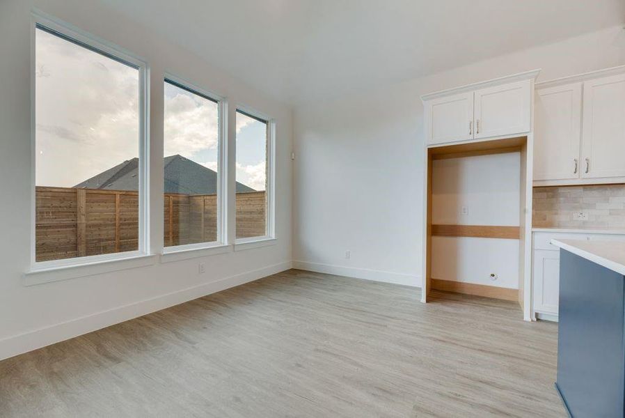 Unfurnished dining area featuring light wood-style floors and baseboards
