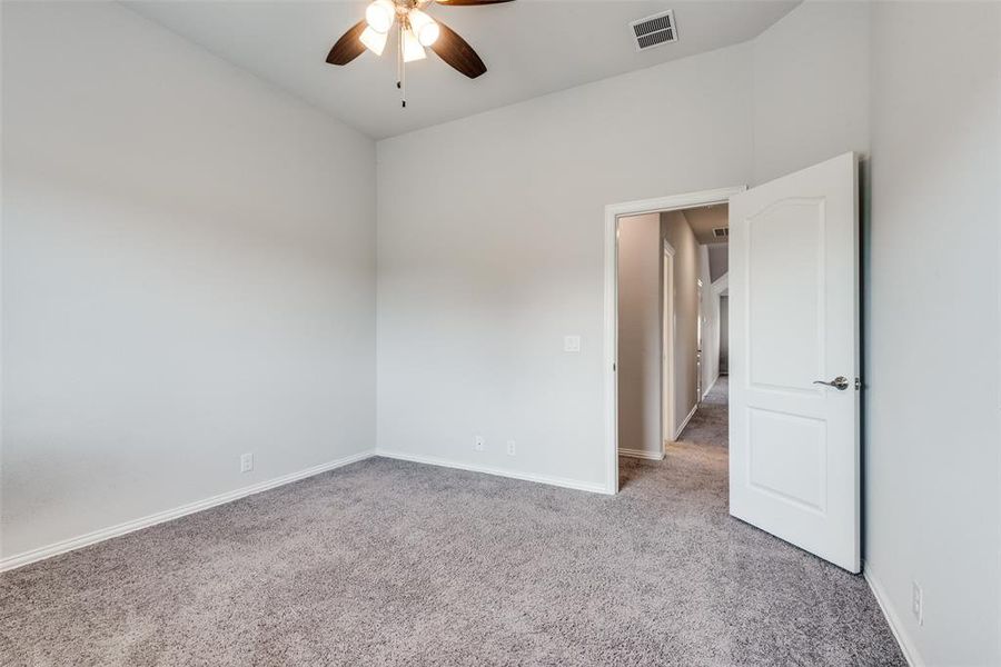 Carpeted empty room with ceiling fan