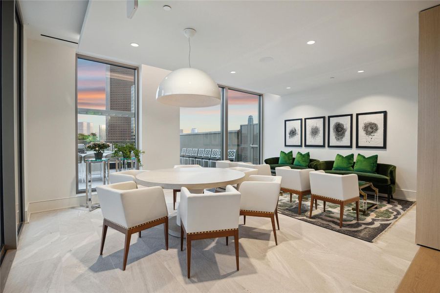 A secondary conversation area across the other side of the lounge with round table for games and visual access to the outdoor grill area