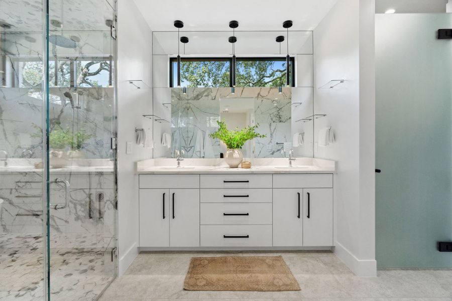 Luxurious primary bathroom featuring dual sinks, quartz countertops, and expansive Italian tilework.