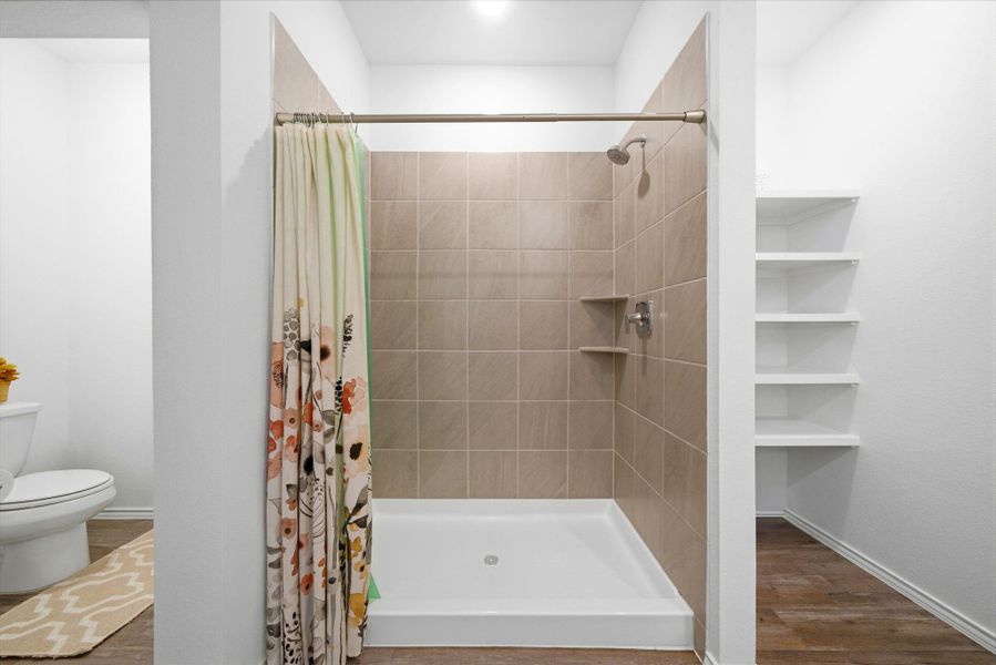 Modern retreat: spacious shower, low-maintenance vinyl floors, and a discreet toilet nook for thoughtful design.