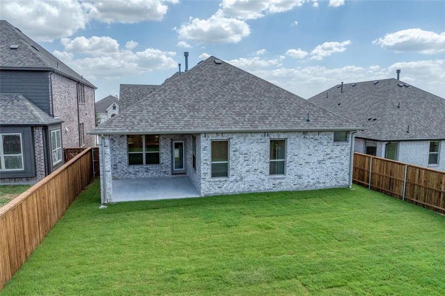 Rear view of property with a patio area, roof with shingles, brick siding, and a fenced backyard Rear view of property with a patio area, roof with shingles, brick siding, and a fenced backyard