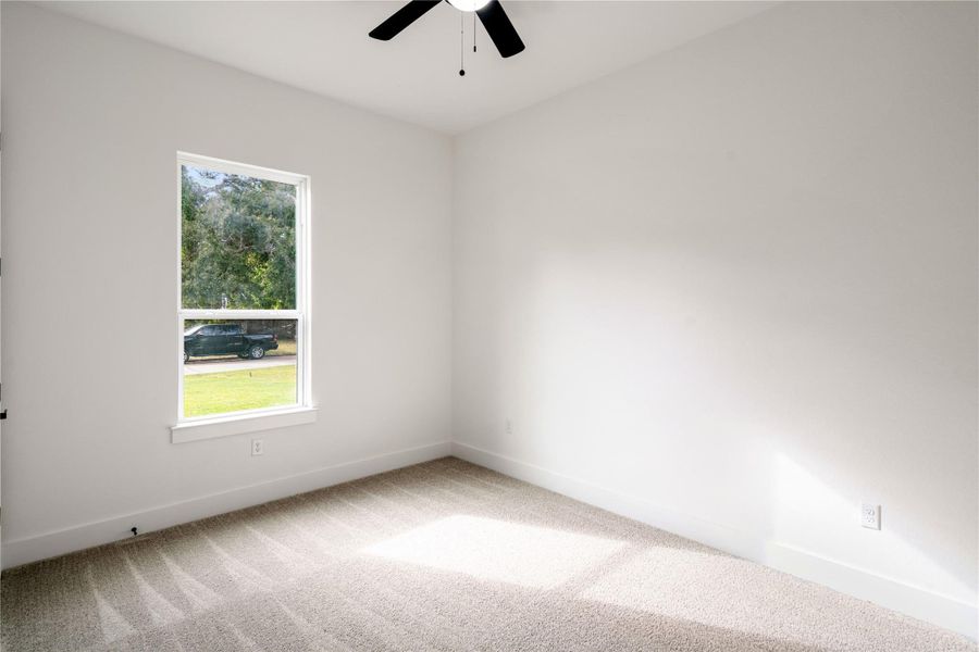 Bright and airy bedroom with plush carpeting and a serene view, perfect for relaxation.