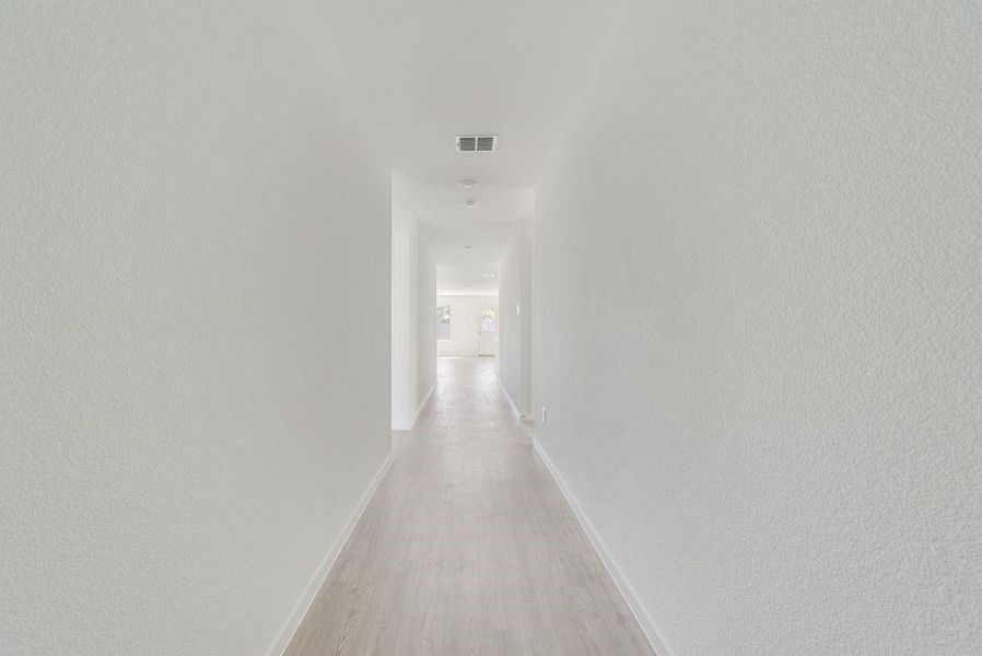 Hall featuring light wood-style floors and baseboards Hall featuring light wood-style floors and baseboards
