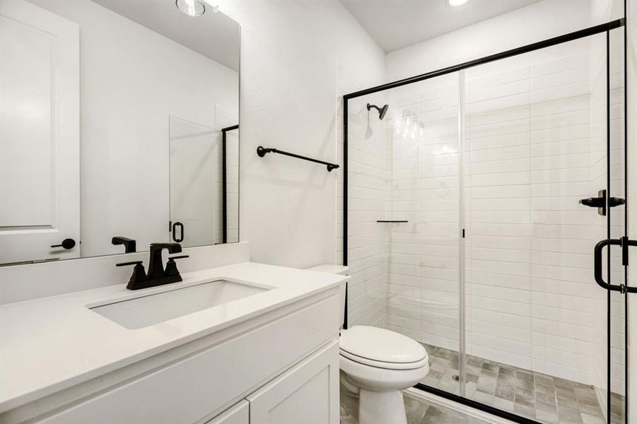 Bathroom featuring a stall shower, vanity, and recessed lighting