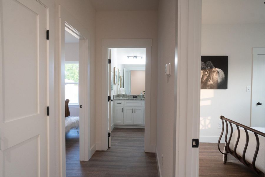 Corridor with dark wood-style flooring, a sink, and baseboards