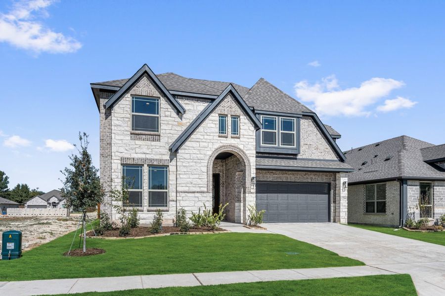 Two-story home with white stone and brick exterior, arched entry, and two-car garage Two-story home with white stone and brick exterior, arched entry, and two-car garage
