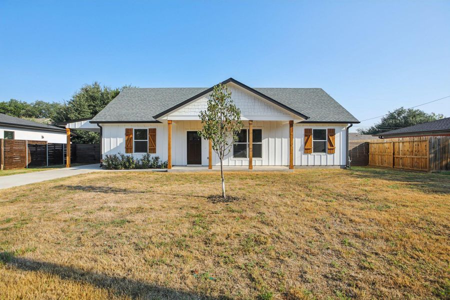 Modern farmhouse style home with board and batten siding, a porch, roof with shingles, and concrete driveway
