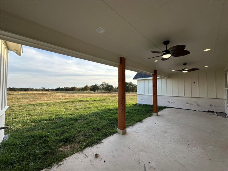 View of yard featuring ceiling fan, a rural view, and a patio