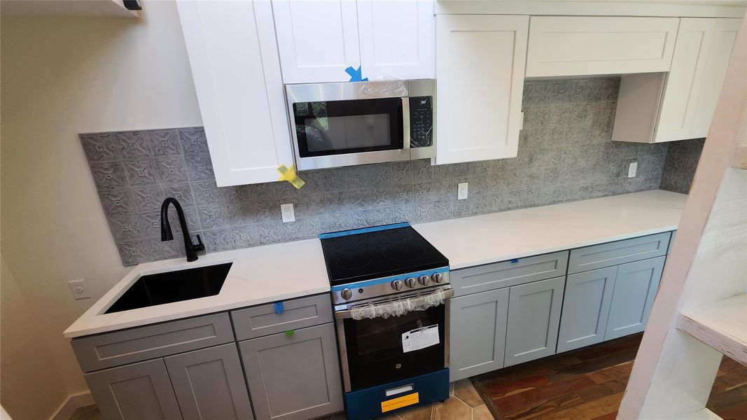Kitchen with cabinets extending into living room with space for TV. Kitchen with cabinets extending into living room with space for TV.