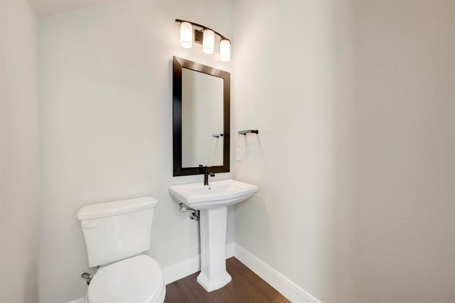 Bathroom with toilet and dark wood-type flooring Bathroom with toilet and dark wood-type flooring